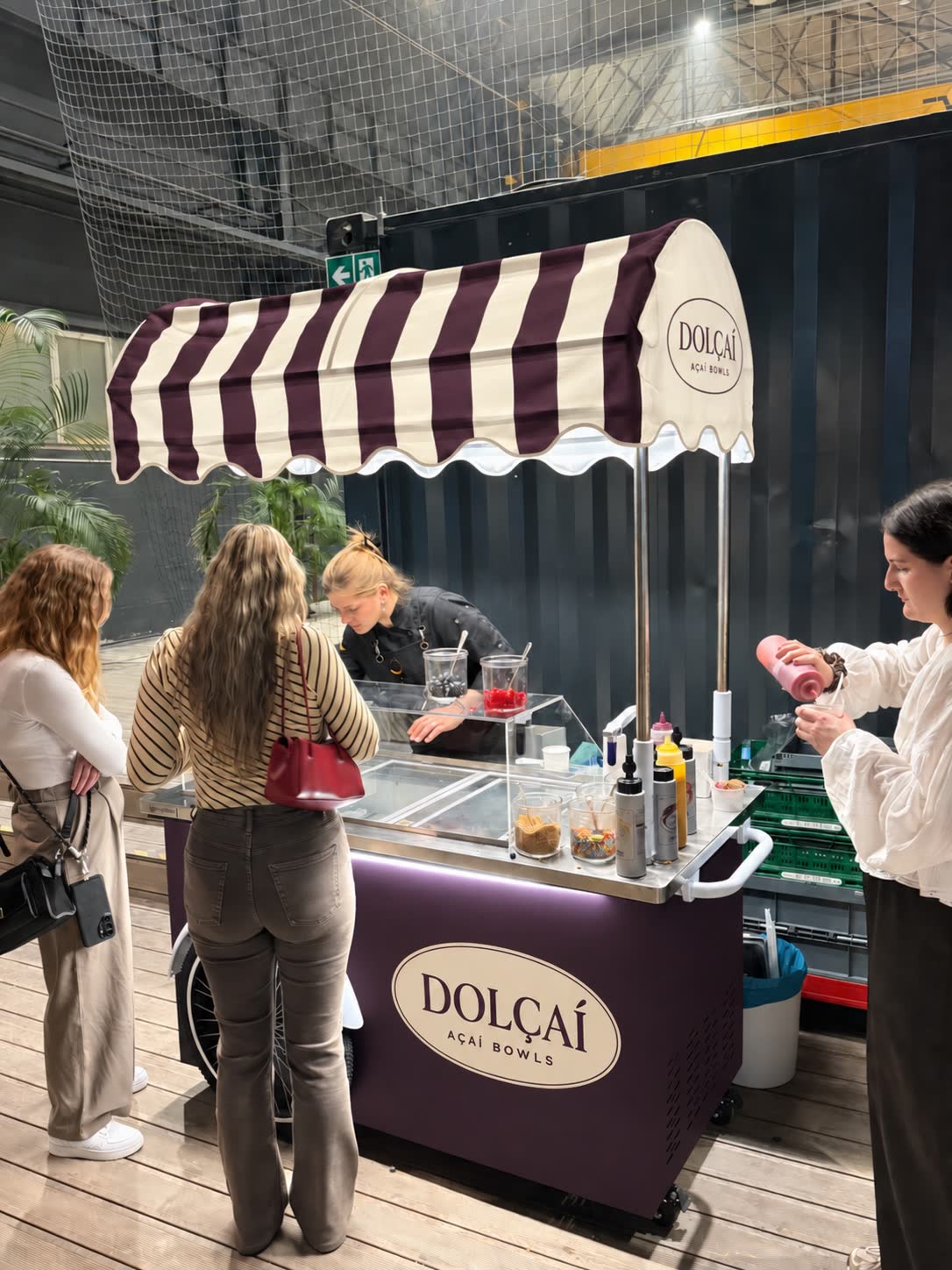 Dolçaí-Mitarbeiterin serviert Açaí Bowls an Gäste bei einem Beauty-Event