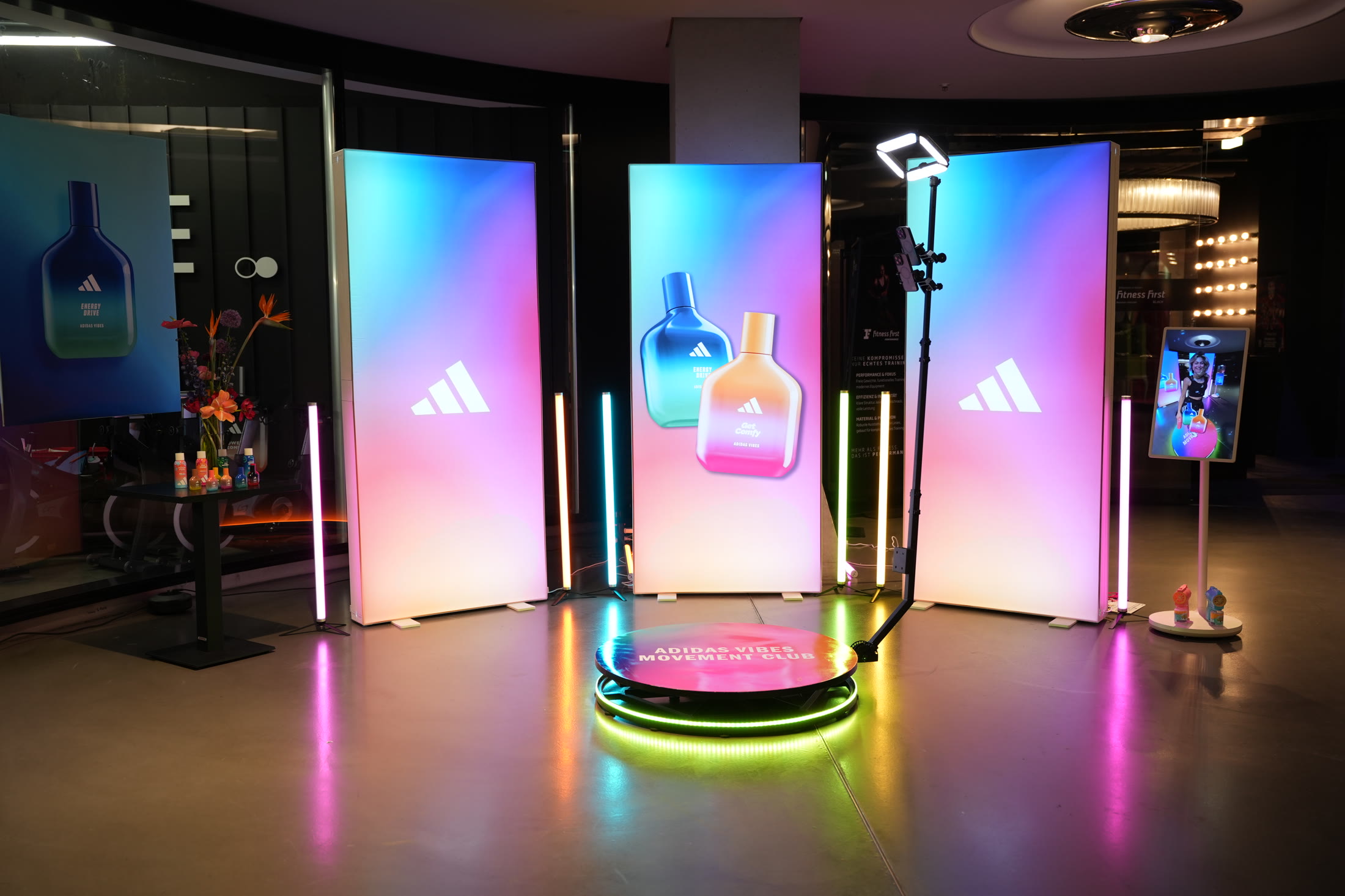 adidas Vibes Movement Club mit vier farbig leuchtenden Markenwänden, 360-Grad-Plattform und Sharing Screen