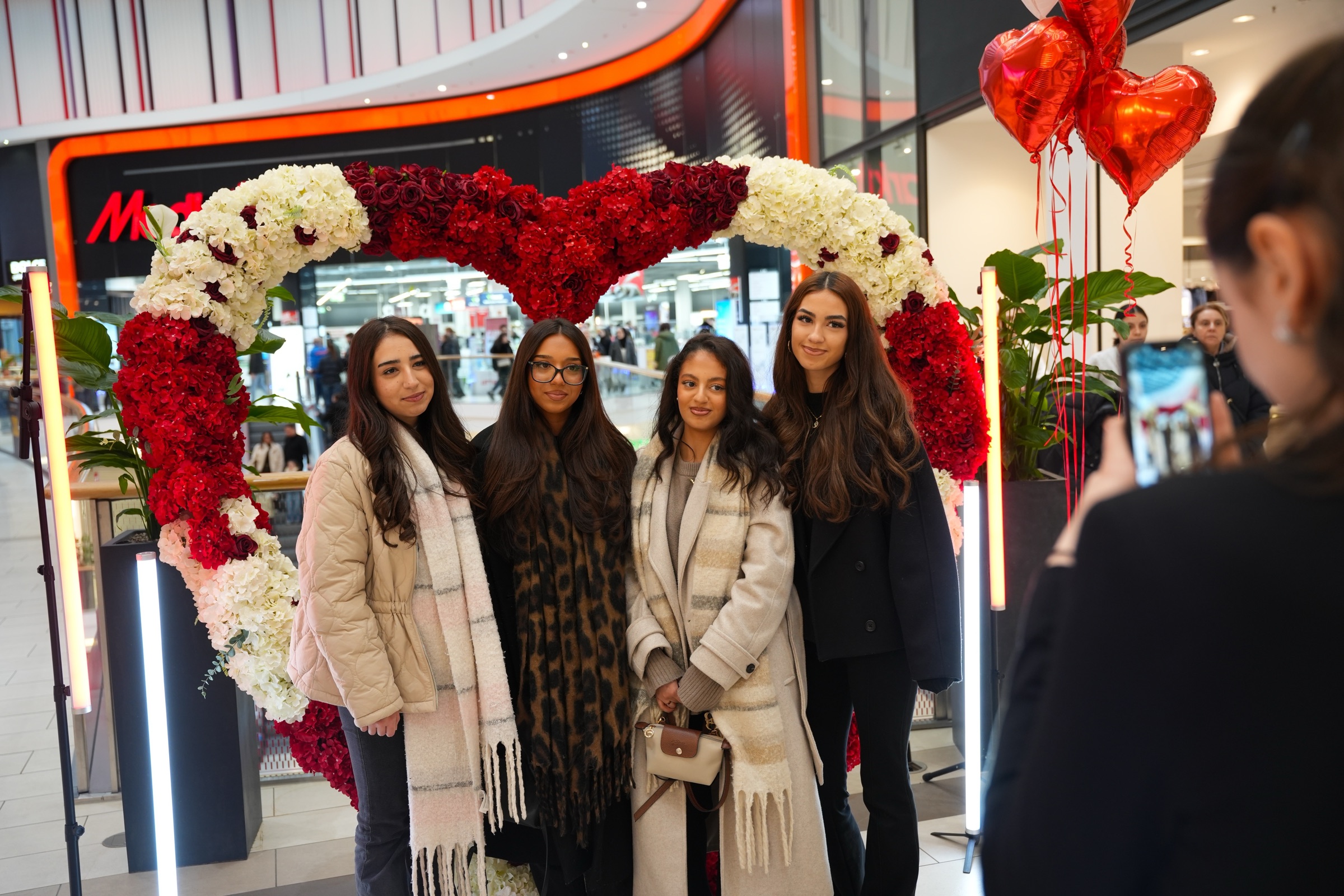Besucherinnen und Besucher vor dem Blumenherz der Valentine Days im Aquis Plaza